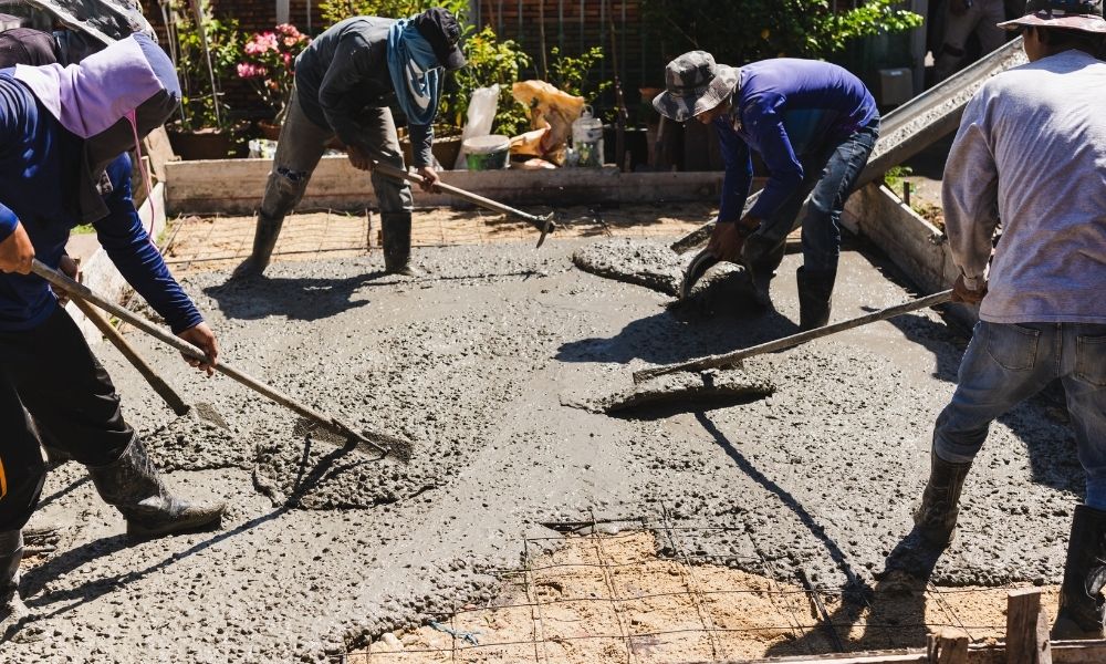 zdjęcie przedstawiające pracowników wyrównujących beton na wylewkę
