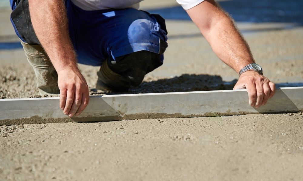 zdjęcie przedstawiające pracownika wyrównującego wylewkę betonową
